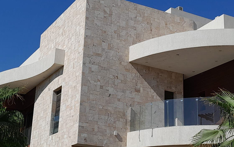 Contemporary villa with natural stone cladding and deep facade openings